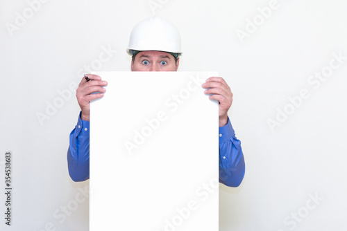 Close-up Engineer man wearing a helmet and reflector vest, standing and holding a billboard. White background. © ARVD73
