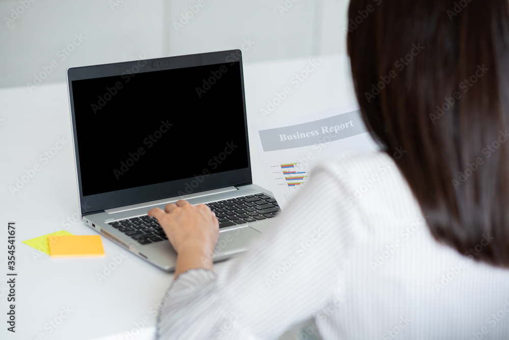 Back view of Business woman using laptop with black screen in office. Photo design with copy space for mock up for business concept Back view of Business woman using laptop with black screen in office. Photo design with copy space for mock up for business concept