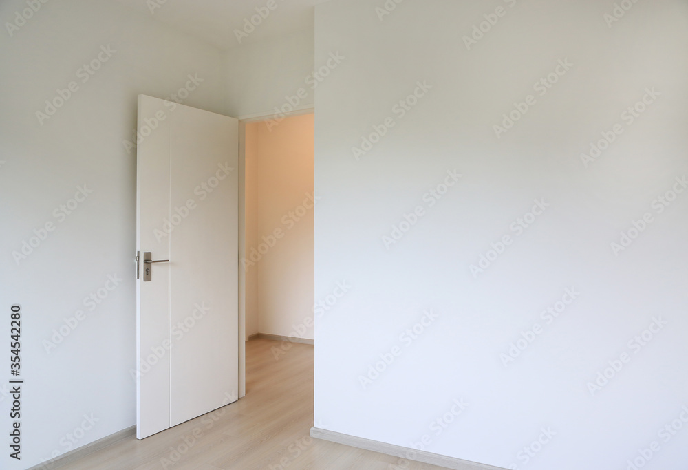 Fototapeta premium Open door in the white room of new house