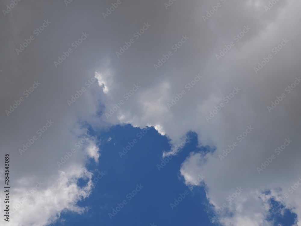 Obraz premium ant's eye view of fat white clouds moving with blue sky background.