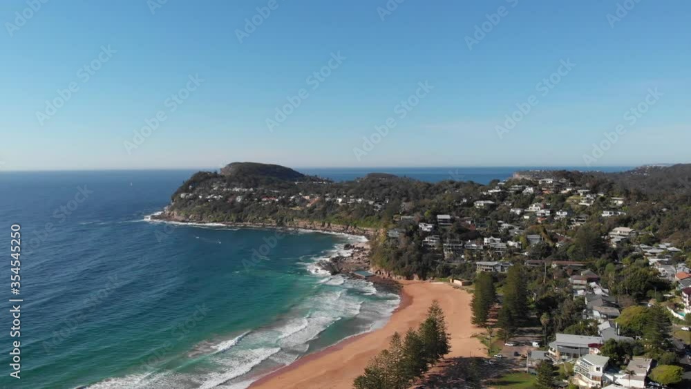 Waves crashing on sandy beach of idyllic seas side town, aerial Waves crashing on sandy beach of idyllic seas side town, aerial