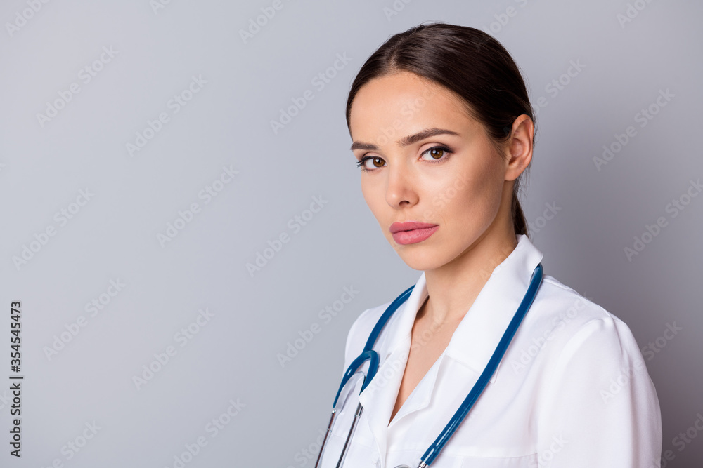 Closeup profile photo of attractive serious family doc not smiling experienced professional listen patient focused wear medical uniform lab coat stethoscope isolated grey background Closeup profile photo of attractive serious family doc not smiling experienced professional listen patient focused wear medical uniform lab coat stethoscope isolated grey background