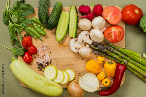 different vegetables on a wooden cutting board with salt and seasonings 