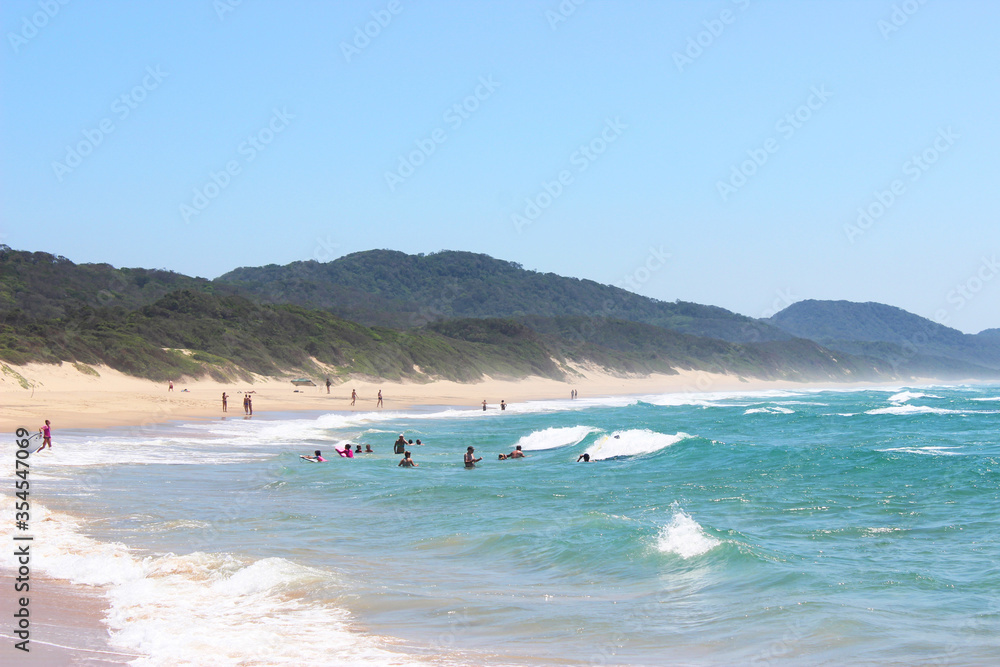 Obraz premium People swimming on long sandy beach