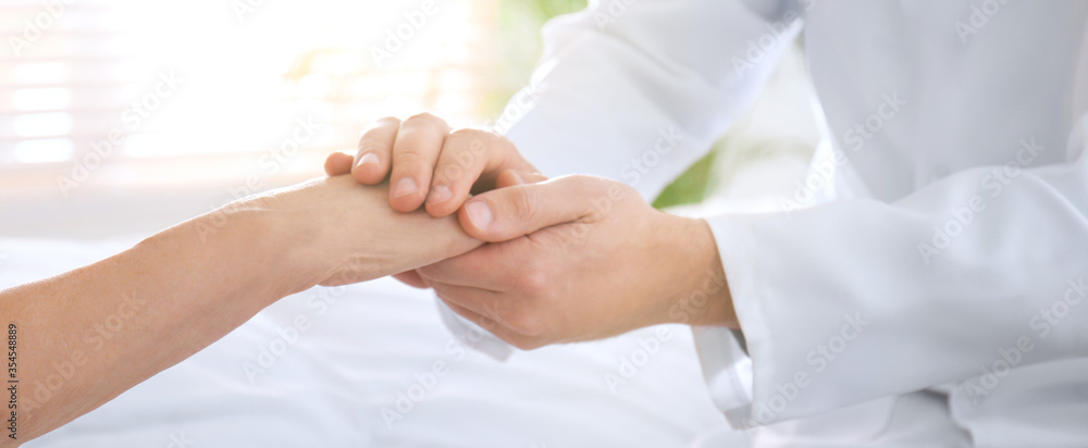 Doctor and senior patient holding hands in hospital, closeup. Banner design Doctor and senior patient holding hands in hospital, closeup. Banner design