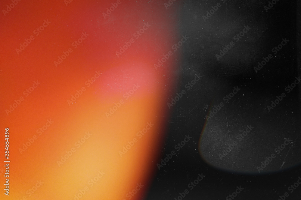 Orange light effect on black background. Abstract wallpaper. Retro film photography effect