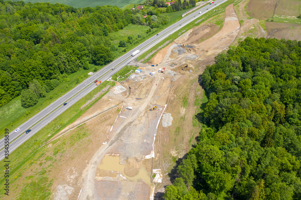 Road Construction Site near the highway with machinery, bulldozer, excavation from above. 4K video, top down view.