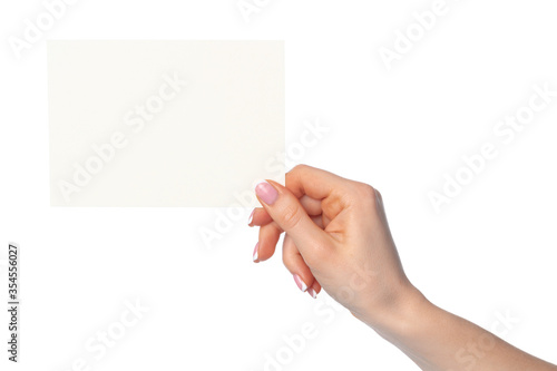 Woman's hand holding blank white sheet of paper isolated on white