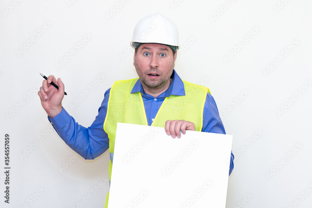 Portrait of middle-aged handsome worker wearing white helmet holding pen blank paper sheet for text. white studio background Portrait of middle-aged handsome worker wearing white helmet holding pen blank paper sheet for text. white studio background