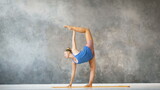 young yoga trainer doing stretching exercises on a yellow rug in a loft studio slow motion