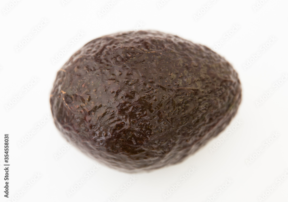 Obraz premium ripe dark avocado on white background