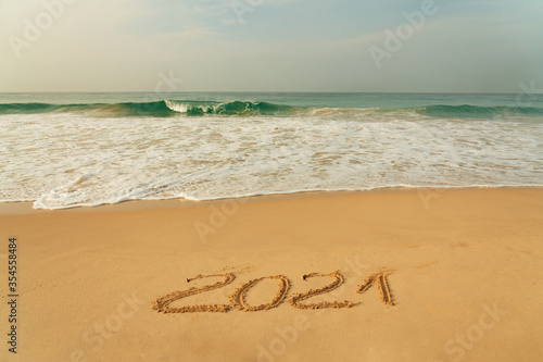 Sand beach with 2021 New Year symbol and blue waves, Sri Lanka