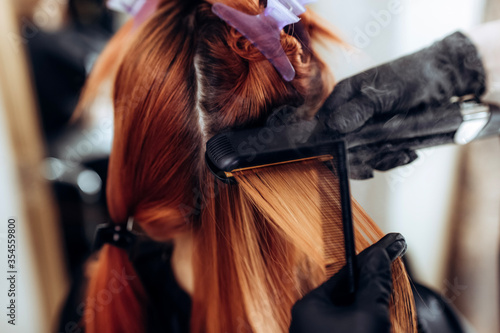 Procedure of keratin hair straightening and restoration, saturation with proteins. Redhead hair