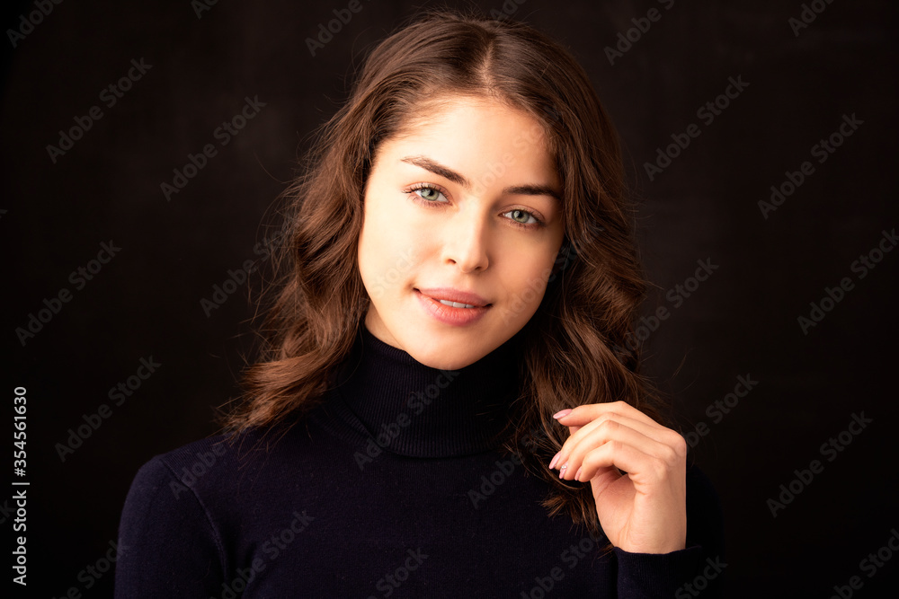 Attractive young woman close-up studio portrait at isolated dark background Attractive young woman close-up studio portrait at isolated dark background
