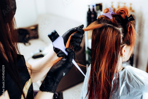 Hairdresser applies a hair mask to the woman in the beauty salon. Botox and keratin hair straightening procedure