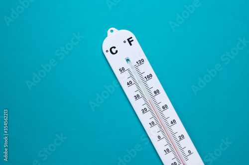Weather thermometer on blue background. Climate control. Top view photo