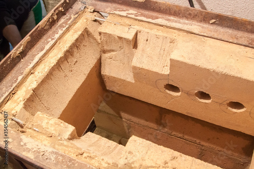 close up view of sauna stove that is being built from fire resistant material in undeveloped interior laid out of foam blocks in country house under construction