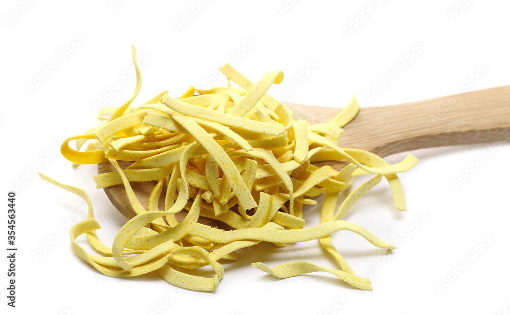 Raw tagliatelle pasta noodles  with wooden spoon isolated on white background