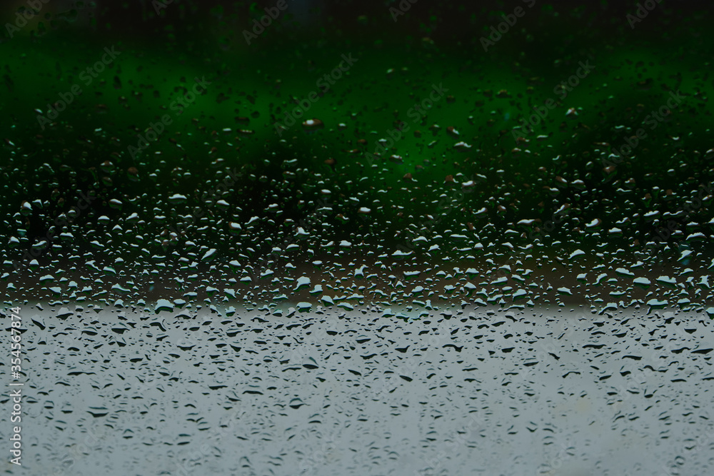 Rain drops after the cloudburst on the window. Green background. Rain drops after the cloudburst on the window. Green background.