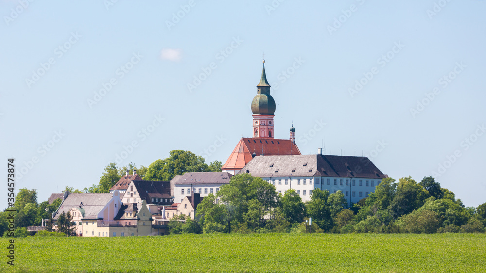 Panorama of Andechs abbey with lush, green meadow.