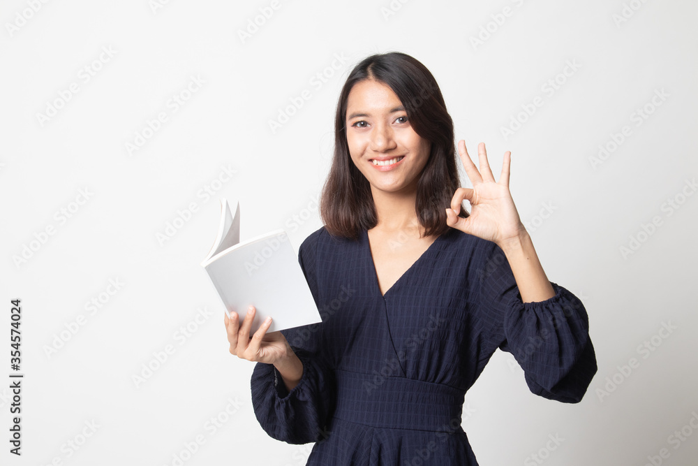 Young Asian woman show OK with a book. Young Asian woman show OK with a book.