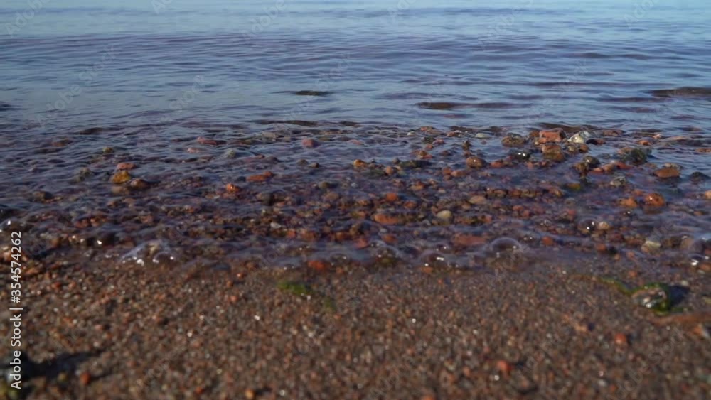 Waves on the sea in Sunny weather. Calm sea and waves during the day on the beach close-up. Waves on the sea in Sunny weather. Calm sea and waves during the day on the beach close-up.