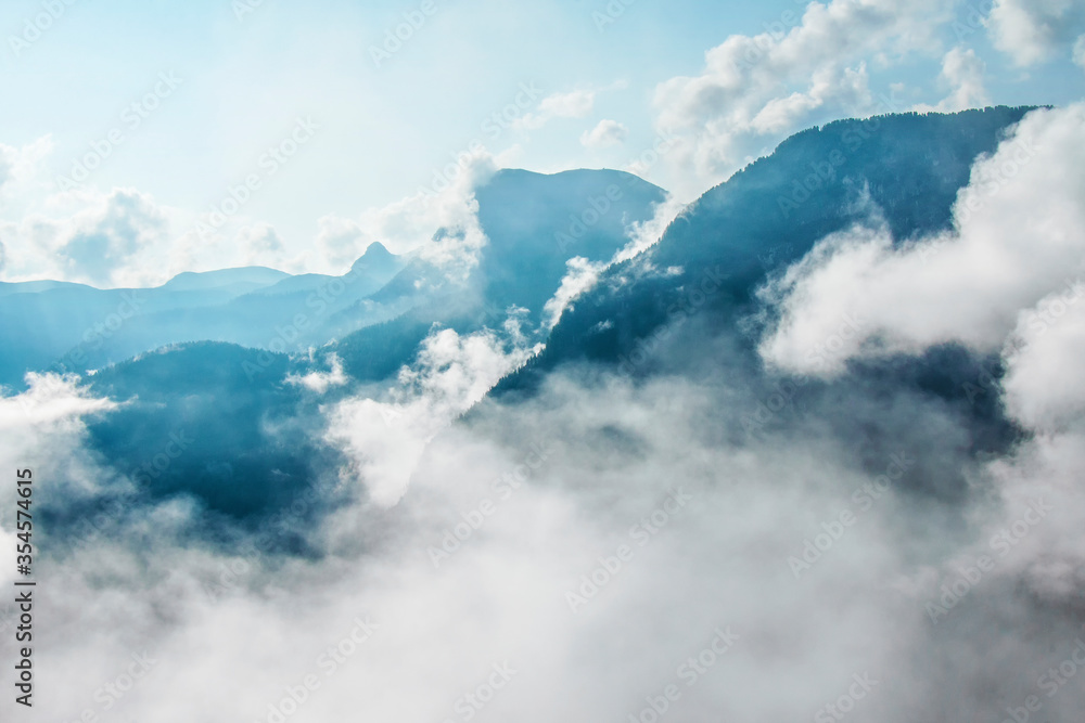 Photo of atmospheric blue misty mountains with clouds in the sky