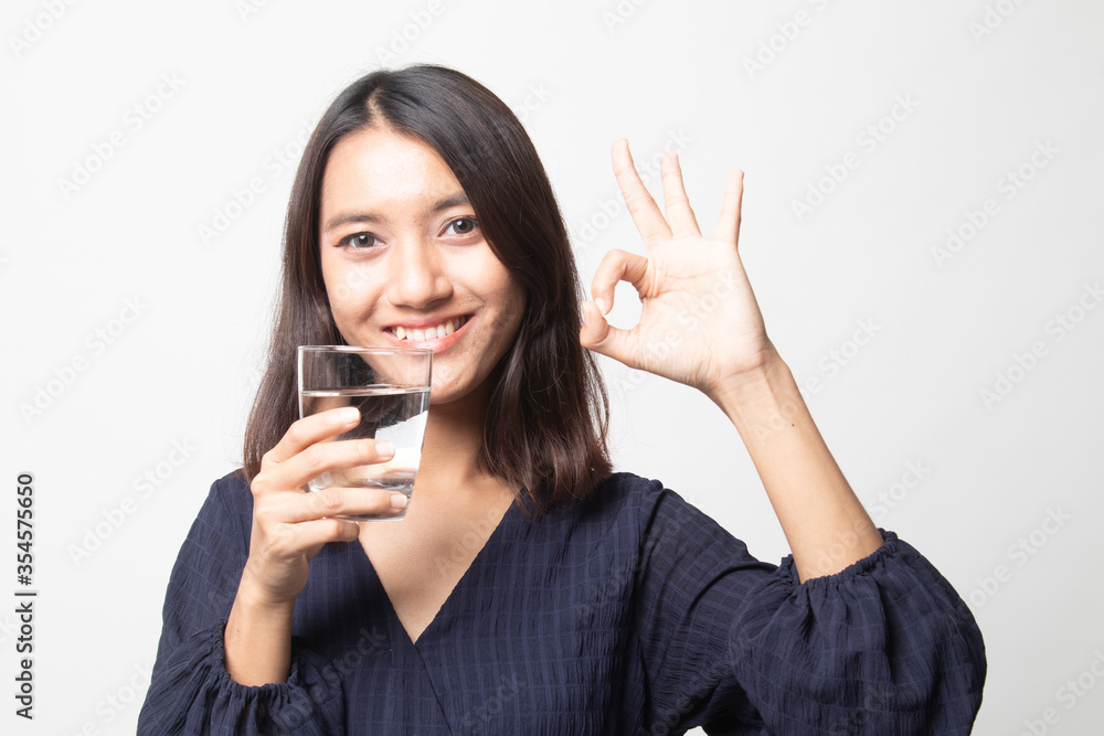 Young Asian woman show OK with a glass of drinking water. Young Asian woman show OK with a glass of drinking water.