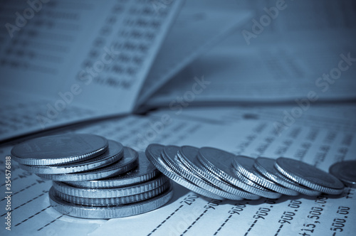 rows of coins on savings account passbook for finance and banking concept abstract blue background