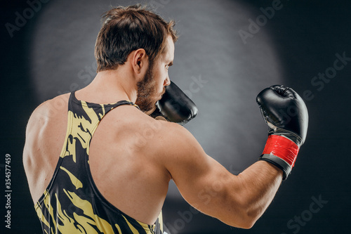 A man in Boxing gloves. A man Boxing on a black background. The concept of a healthy lifestyle © fusssergei