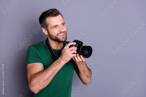Profile side photo of cheerful guy enjoy summer rest weekend hold dslr camera want make photo look copyspace wear casual style clothes isolated over gray color background