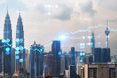 Forex and stock market chart hologram over panorama city view of Kuala Lumpur. KL is the financial center in Malaysia  Asia. The concept of international trading. Double exposure.