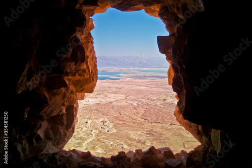 Crack in the rock at the top of the ancient fortification of Masada, Israel shows the view to the dead sea 