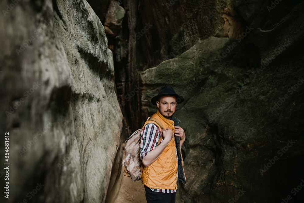 The traveler stands in a mountain cave. Hiking in the mountains