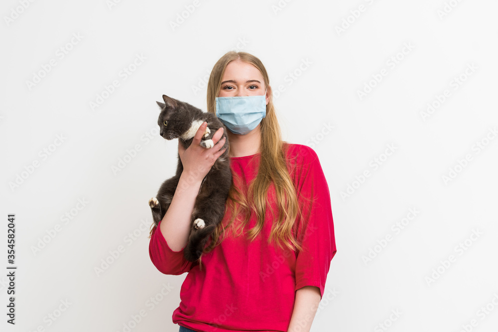 young woman in medical mask holding in arms cute cat and looking at camera isolated on white young woman in medical mask holding in arms cute cat and looking at camera isolated on white