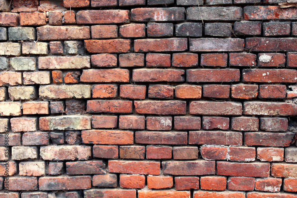 A dirty brick wall of an old rural building under reconstruction in the Central Bohemian Region. Closeup. A dirty brick wall of an old rural building under reconstruction in the Central Bohemian Region. Closeup.