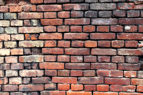 A dirty brick wall of an old rural building under reconstruction in the Central Bohemian Region. Closeup.