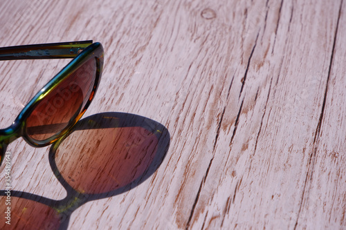Sunglasses reflected onto a wooden background