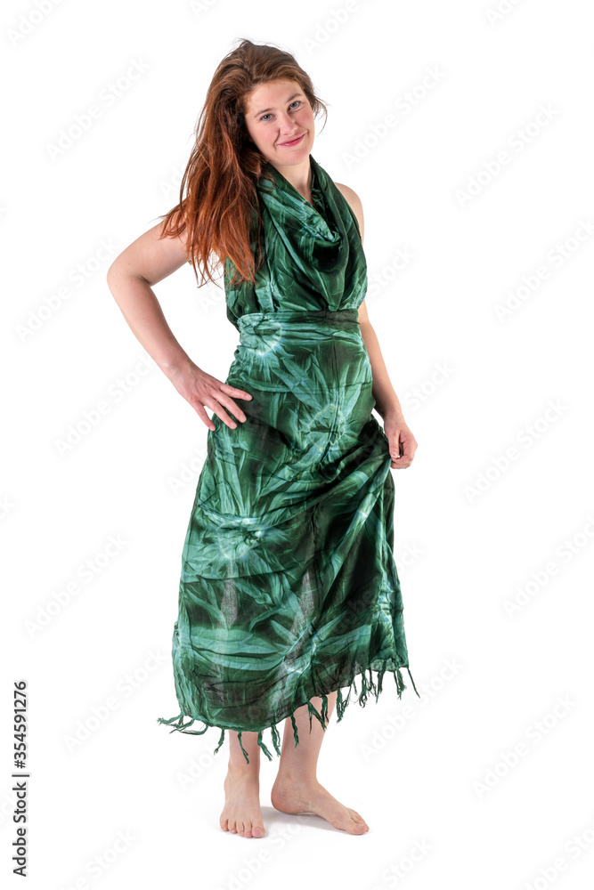 Young woman in dark green dress stands barefoot against white background Young woman in dark green dress stands barefoot against white background