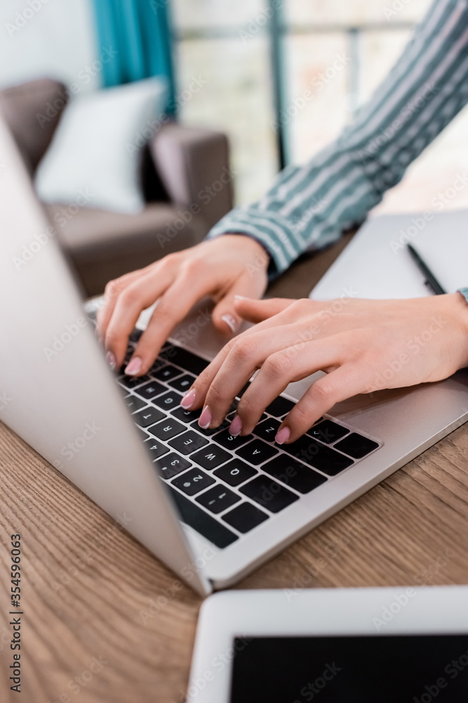 cropped view of young freelancer typing on laptop keyboard cropped view of young freelancer typing on laptop keyboard