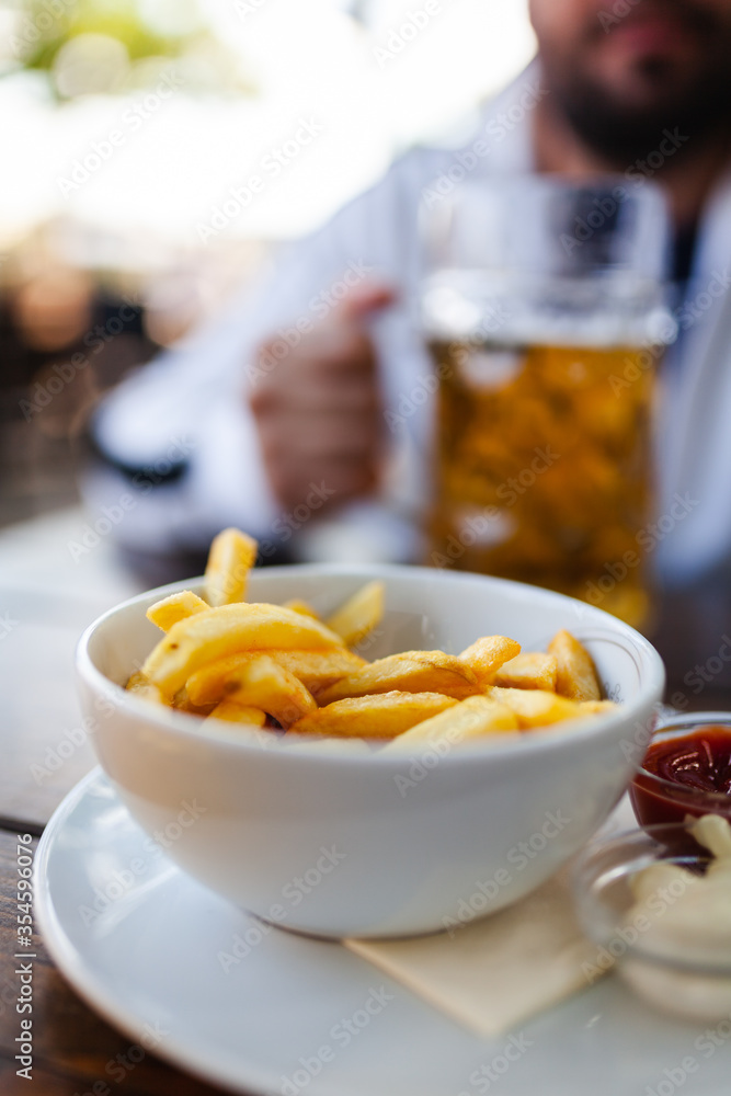 french fries with sauce and glass of cold beer on a wooden table french fries with sauce and glass of cold beer on a wooden table