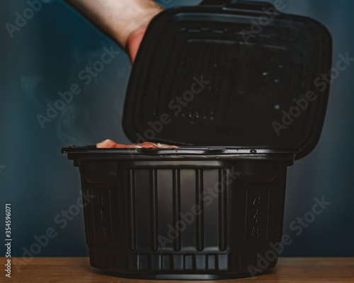 Man cooking self heating hot pot can order to home delivery ready to eat by heat from self heating pad which contains noodle,Sliced wagyu marbled beef,Cantonese vegetables,fried shrimp ball,mushroom. photo