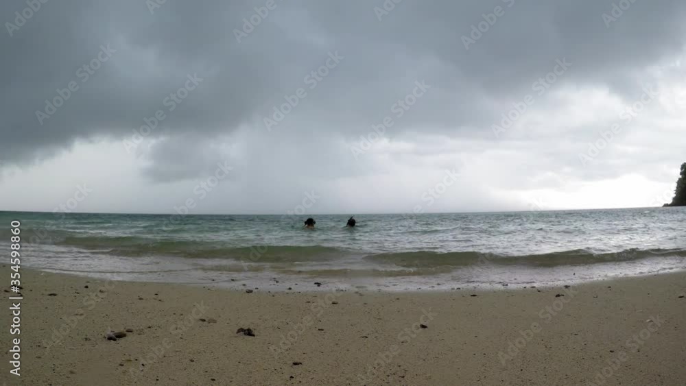 Man and woman sit in water and watch stormy clouds- time-lapse Man and woman sit in water and watch stormy clouds- time-lapse