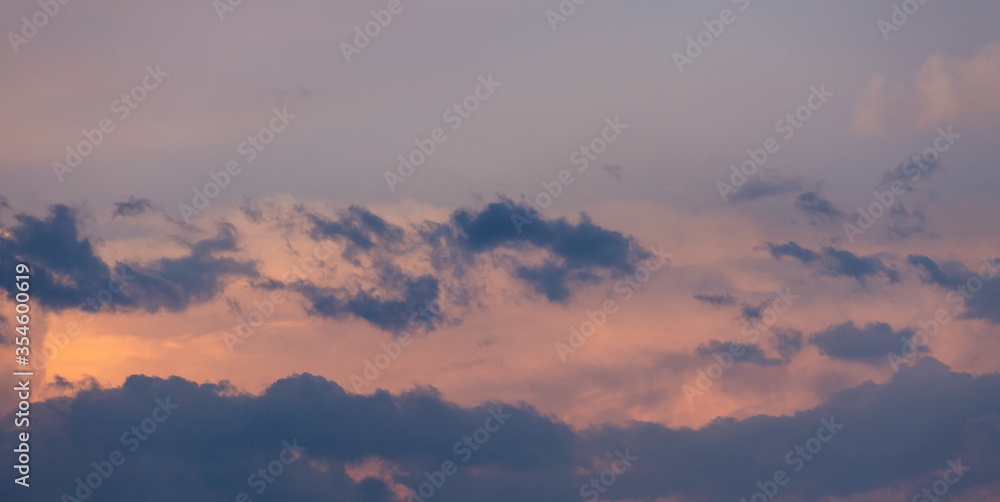 Beautiful dramatic gray and white clouds on blue sky, variety of shapes, silhouettes and shades at sunset time Beautiful dramatic gray and white clouds on blue sky, variety of shapes, silhouettes and shades at sunset time