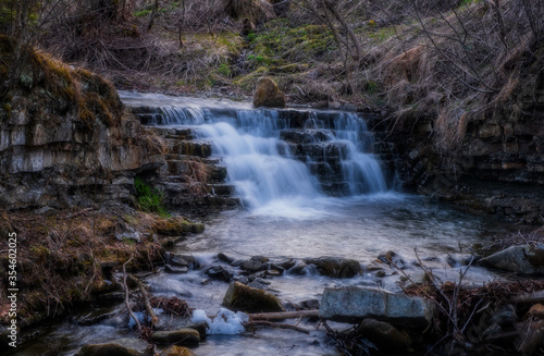 Waterfall Zalotomyatyi at the Zalotomyatyi river in carpatian mountains and green forest. National park Skolivski Beskidy. April 2020