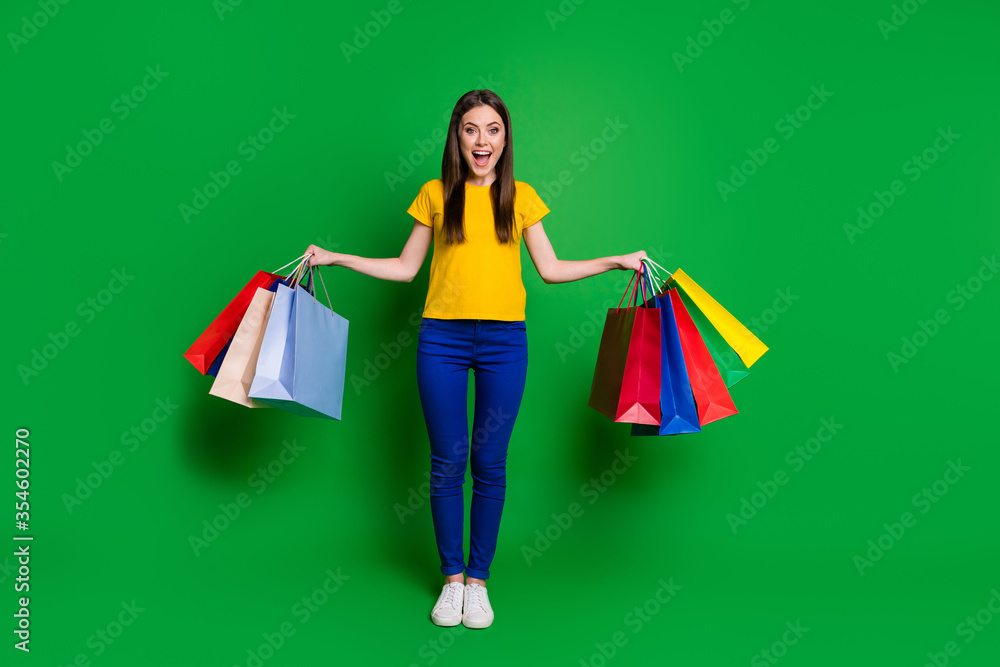 Full length body size view portrait of her she nice attractive lovely fashionable cheerful slim fit thin girl holding in hands new clothes isolated bright vivid shine vibrant green color background Full length body size view portrait of her she nice attractive lovely fashionable cheerful slim fit thin girl holding in hands new clothes isolated bright vivid shine vibrant green color background
