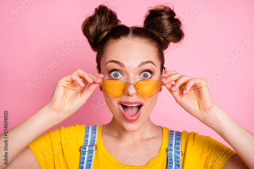 Close-up portrait of her she nice attractive pretty amazed lucky funky cheerful cheery brown-haired girl touching specs good news sale discount reaction isolated over pink pastel color background