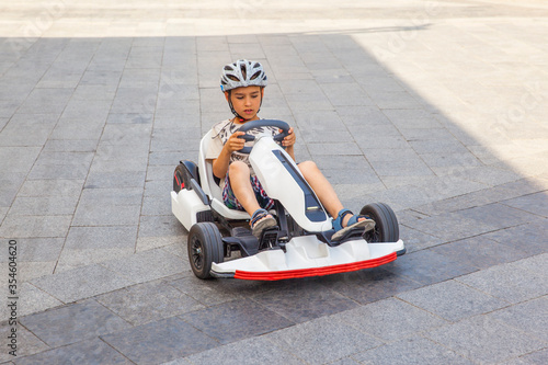 Happy boy riding an electric car