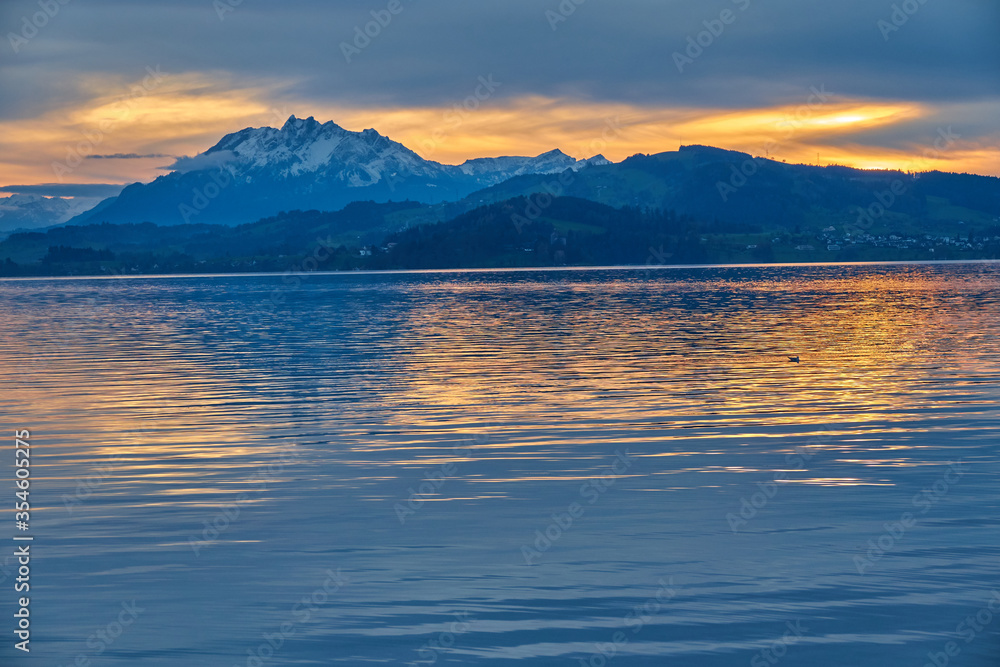 Beautiful landscape with a lake surrounded by high mountains and a cloudy sky at sunset, Switzerland, Lake Zug