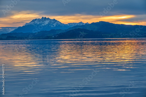 Beautiful landscape with a lake surrounded by high mountains and a cloudy sky at sunset, Switzerland, Lake Zug